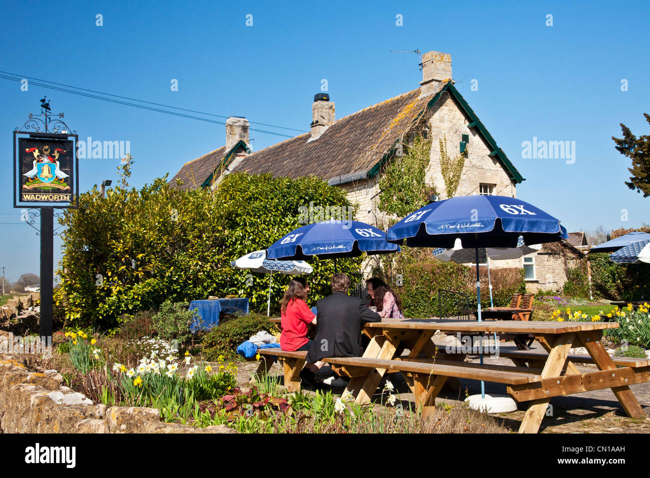 People chatting in a pub garden in the spring sunshine in Wiltshire, England, UK Stock Photo
