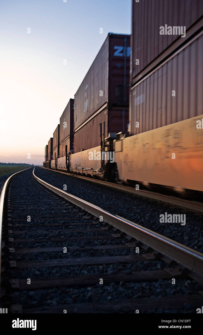 Rail cars carrying containers at sunrise, near Winnipeg, Manitoba Stock Photo