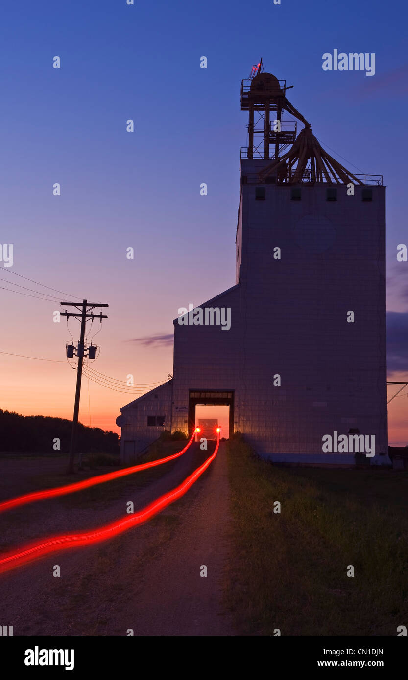 Streak of truck lights and an old grain elevator, Virden, Manitoba Stock Photo