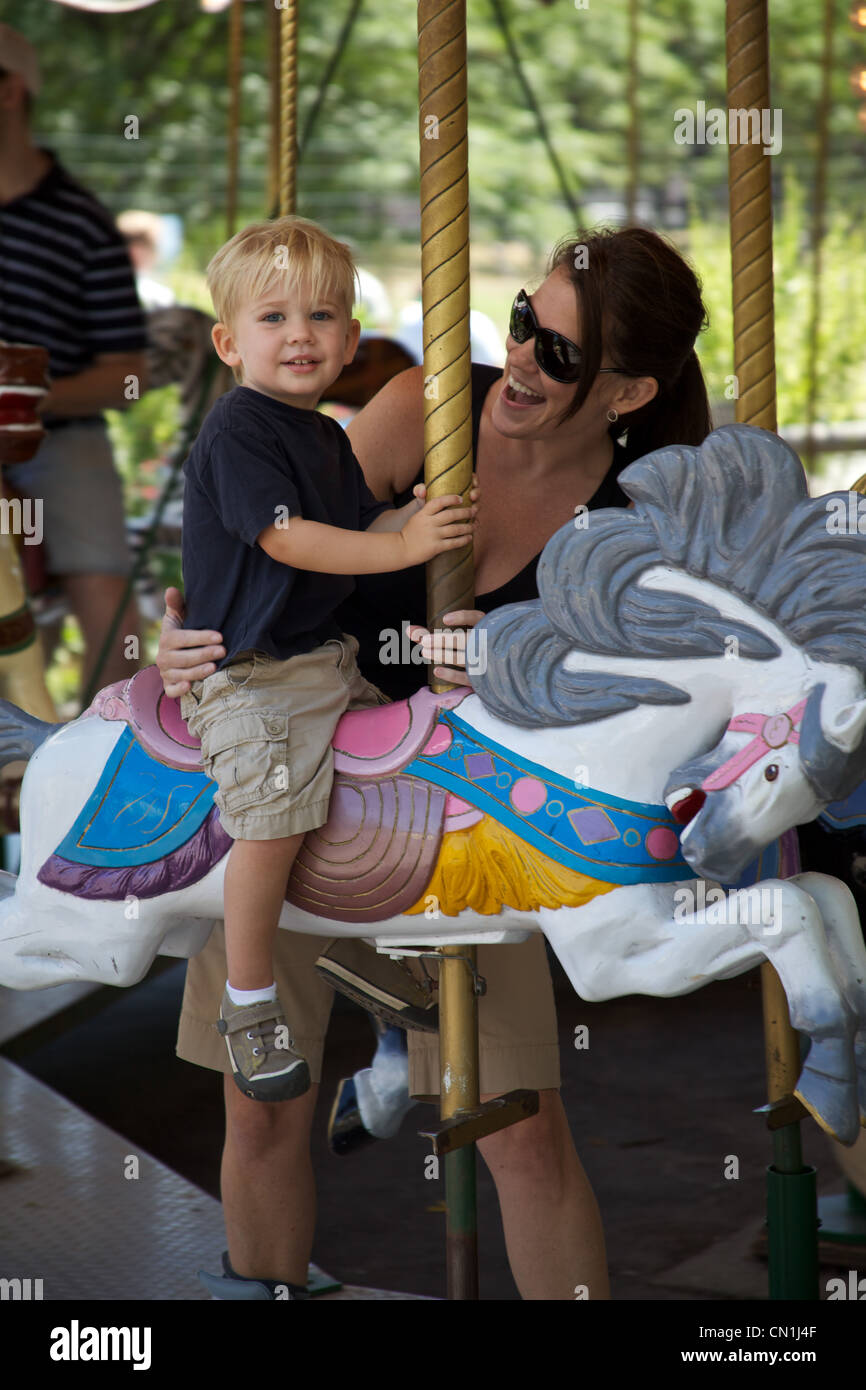 Smiling Mother and Son on Carousel Stock Photo