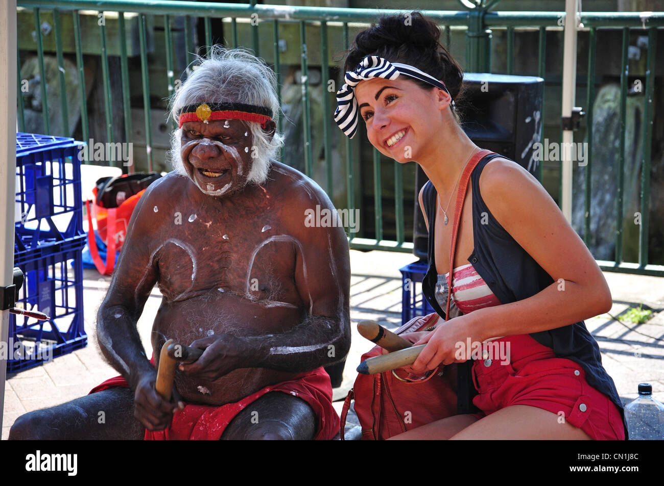 Young woman with painted aborigine man, Circular Quay, Sydney, New South Wales, Australia Stock Photo