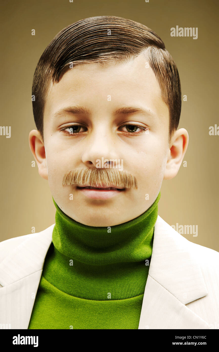 Young boy dressed in beige suit with fake mustache Stock Photo