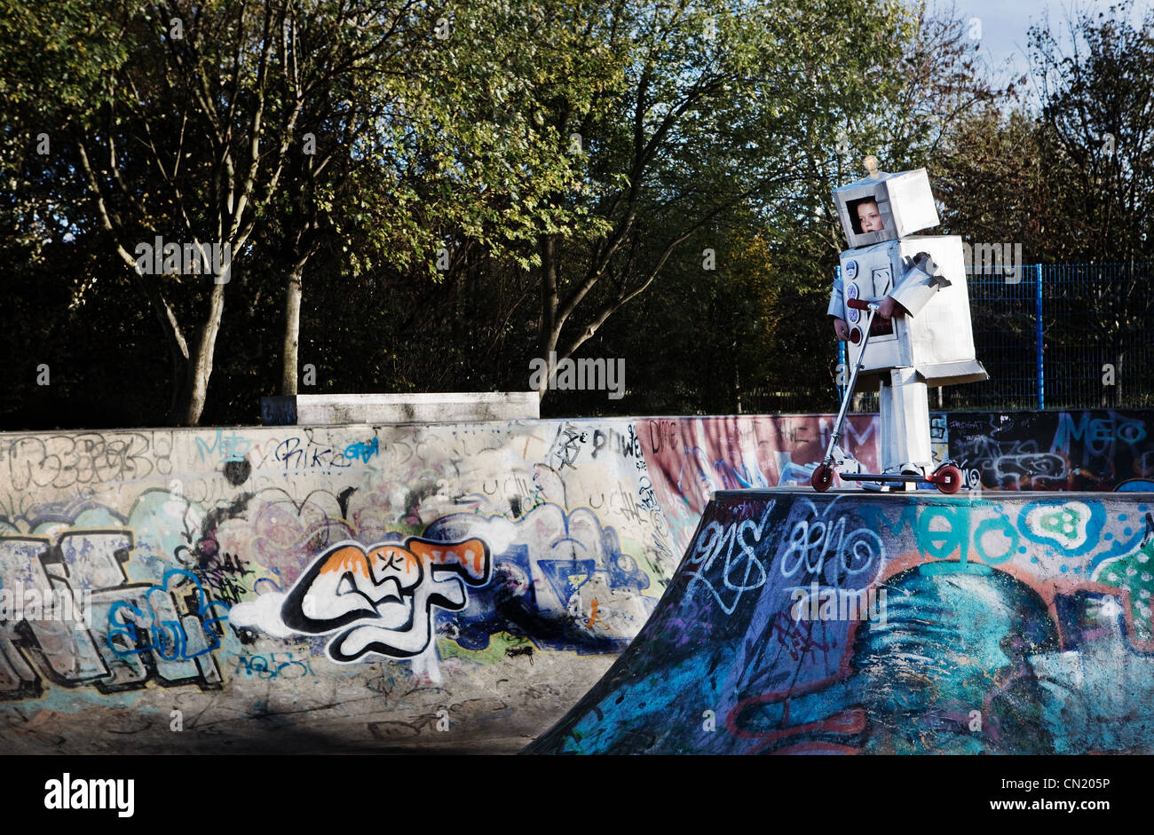 Boy dressed as robot in skate park Stock Photo