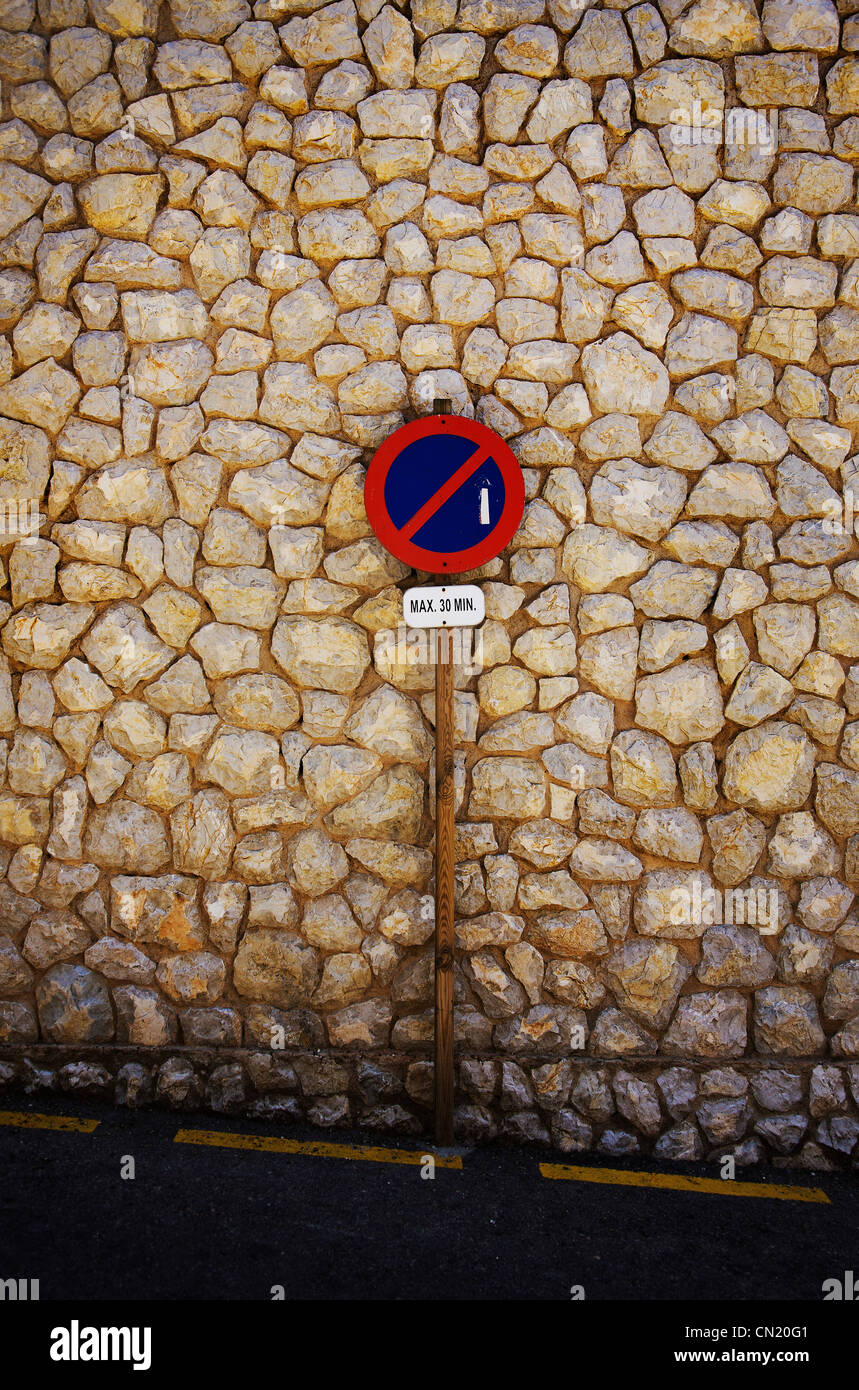 Road sign and stone wall, Majorca, Spain Stock Photo
