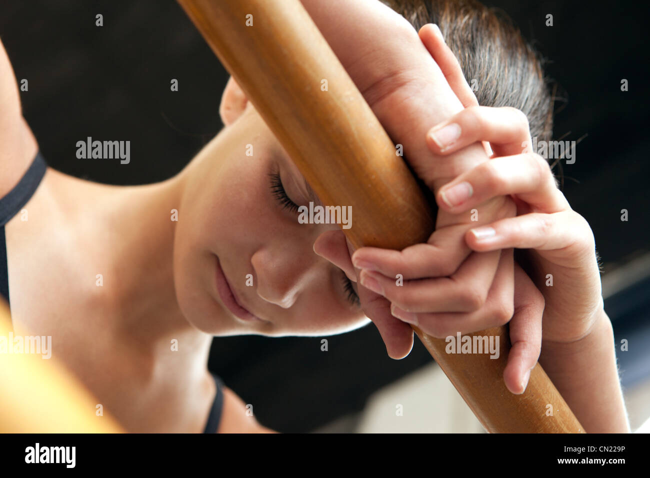 Ballet dancer leaning on bar, eyes closed Stock Photo