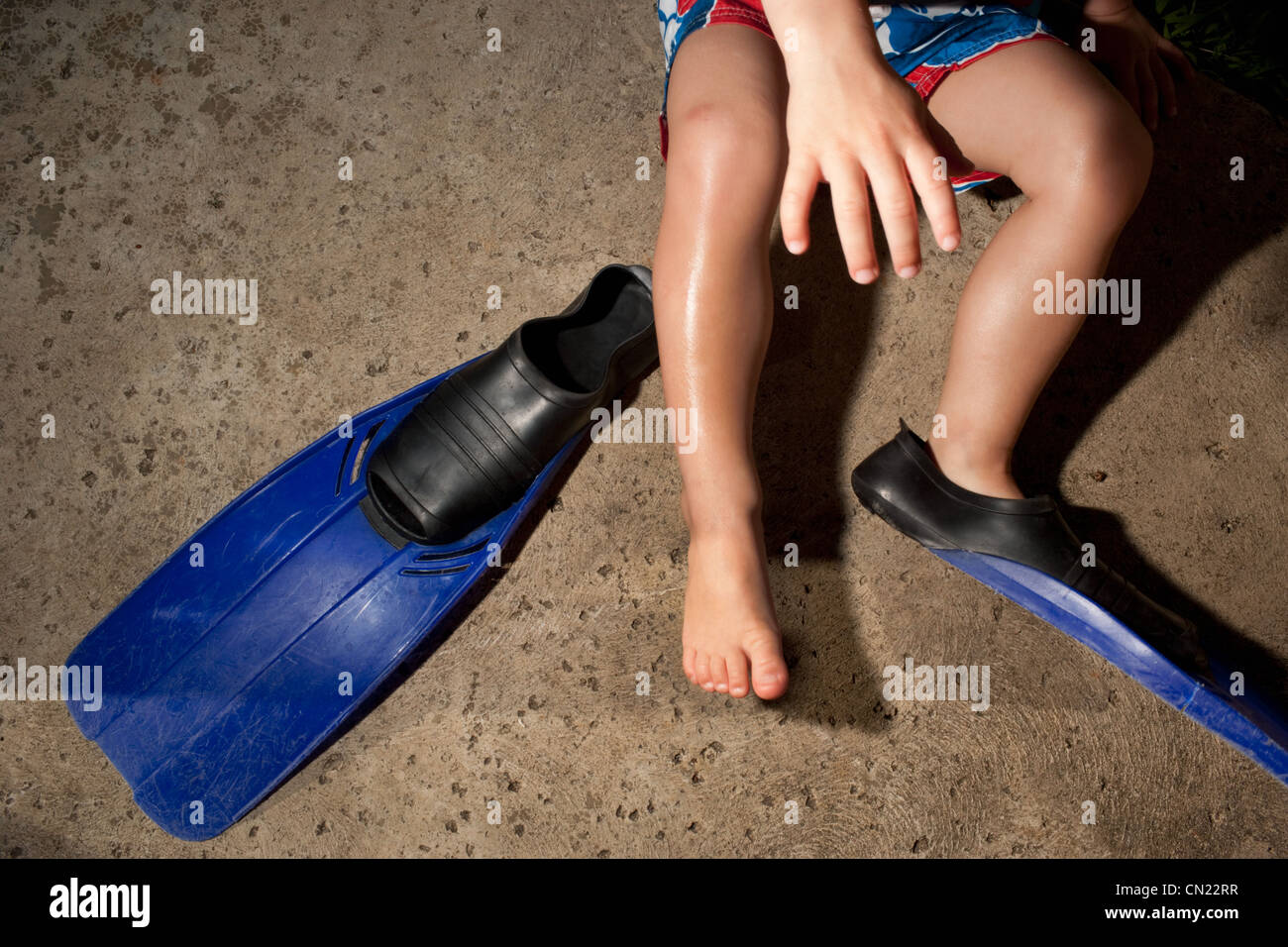 Young boy putting on flippers Stock Photo Alamy