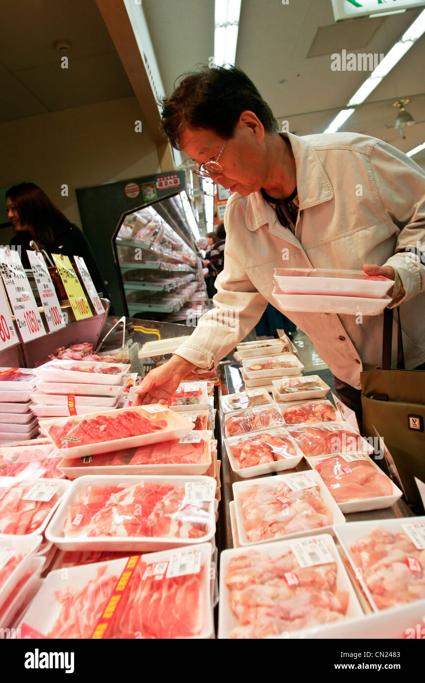A customer selects a package of Wagyu beef at a branch of Uny