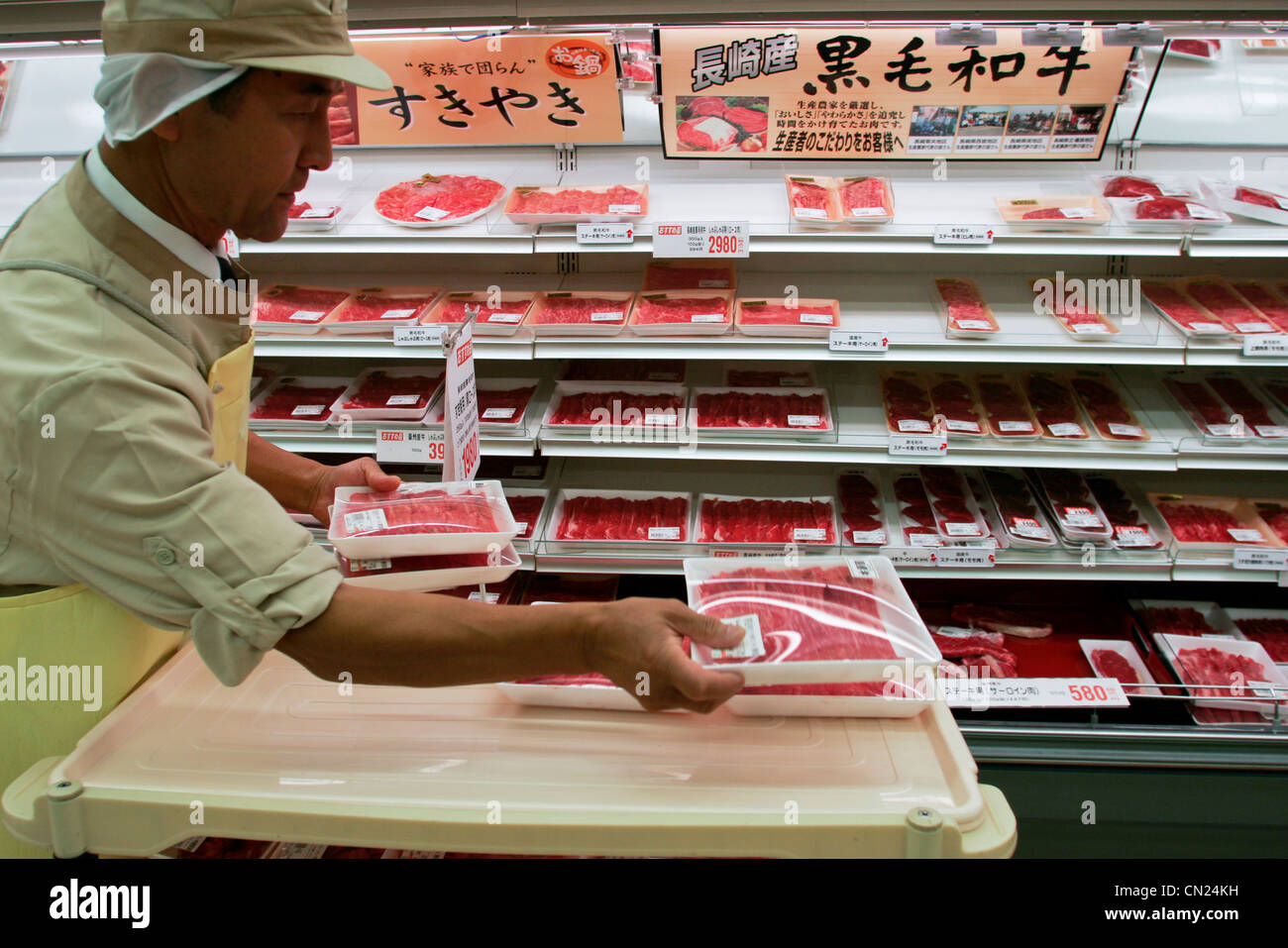 An employee stocks shelves with packs of Wagyu beef at a branch of Uny