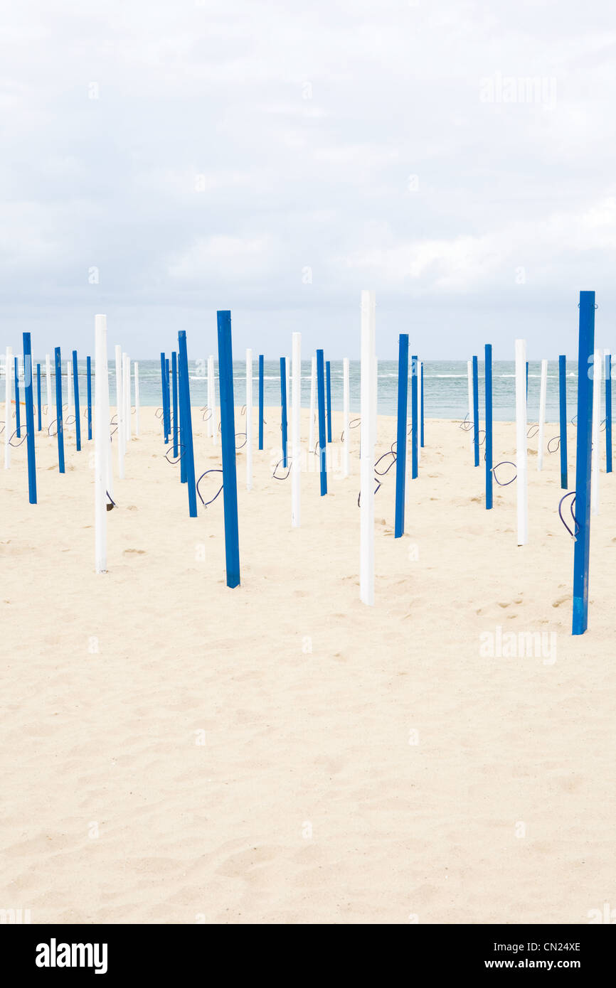 Beach umbrella poles on sandy beach Stock Photo