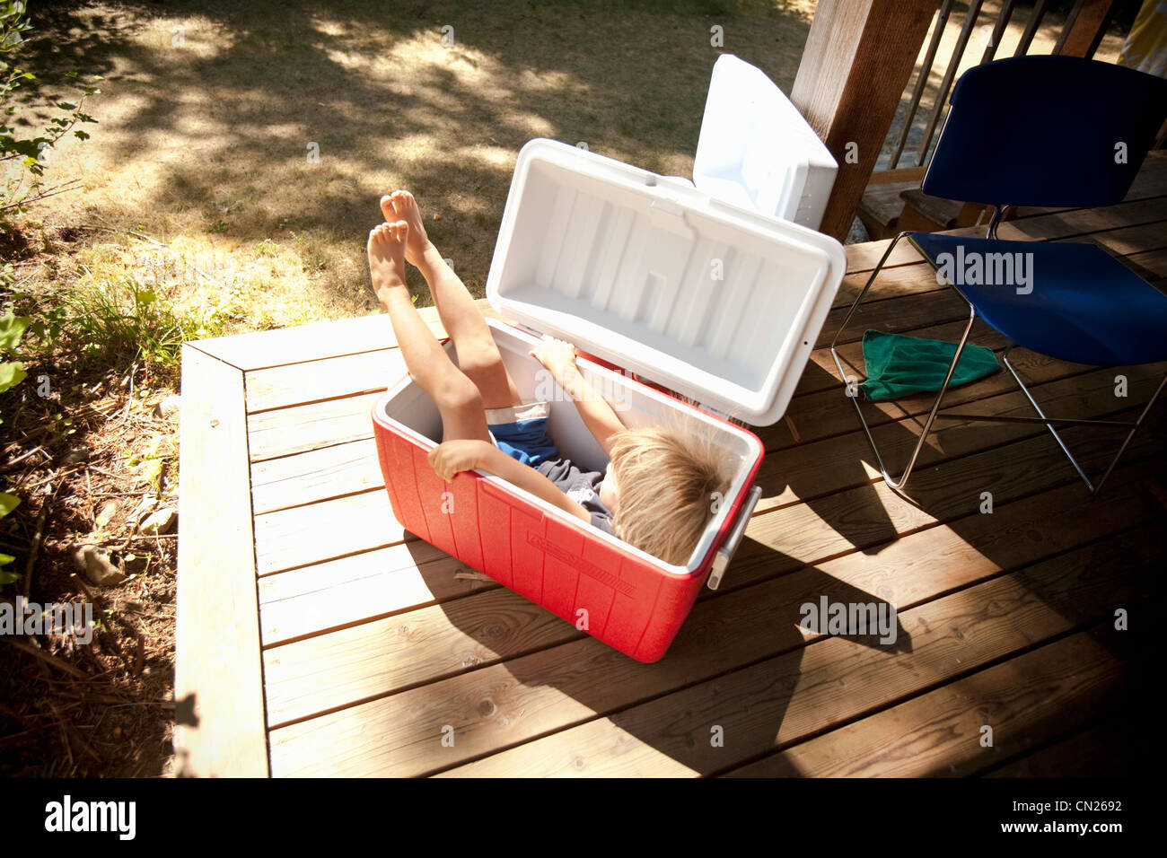Young boy sitting in cool box Stock Photo