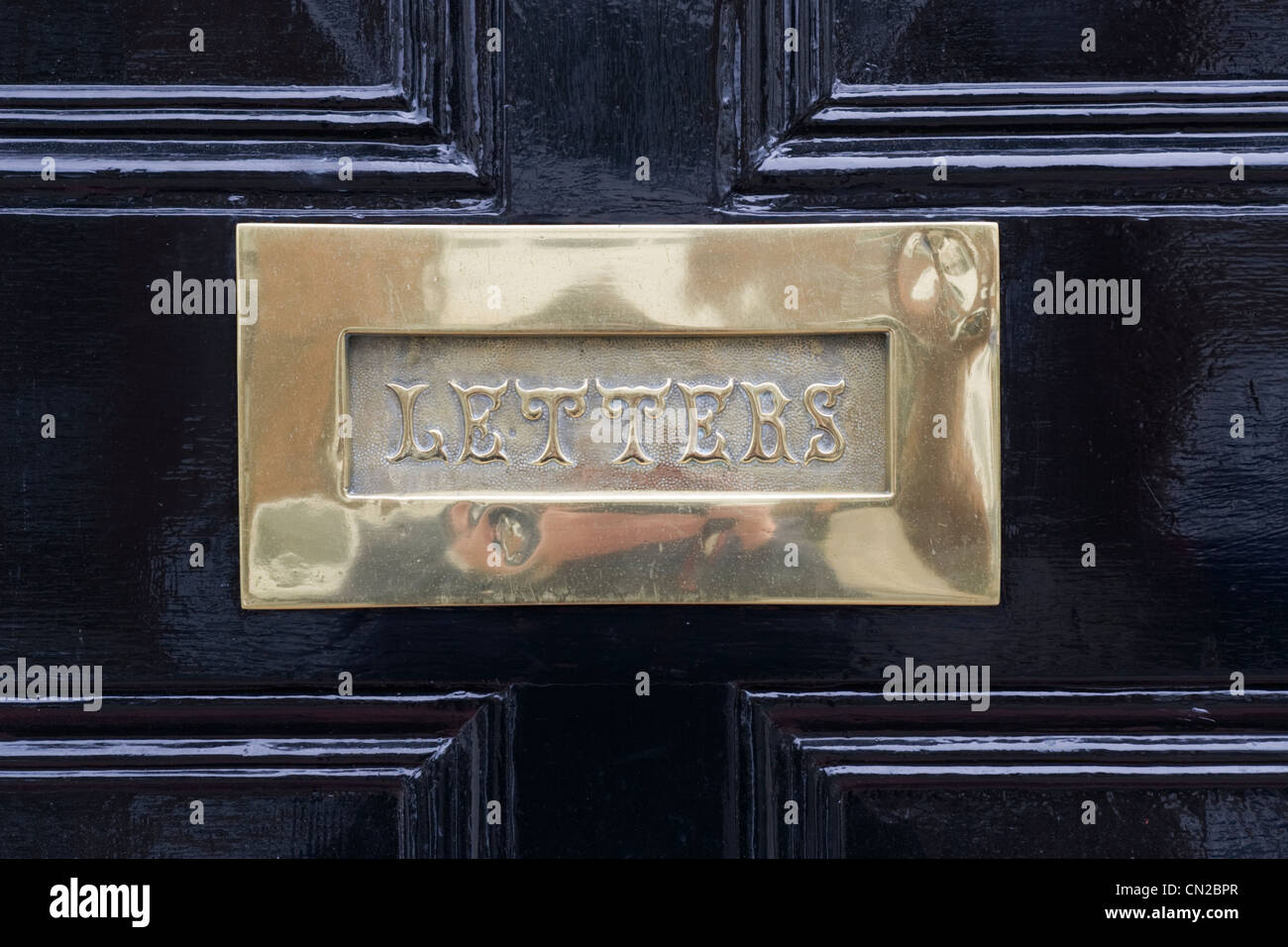 Letter box on black front door, UK Stock Photo