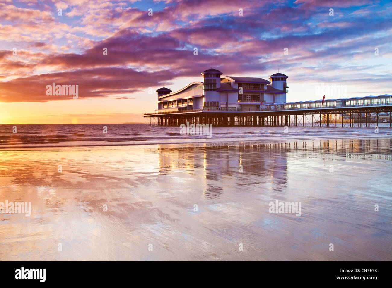 Sunset over the Grand Pier at Weston-Super-Mare, Somerset, England, UK reflected in the wet sand of the beach at high tide. Stock Photo