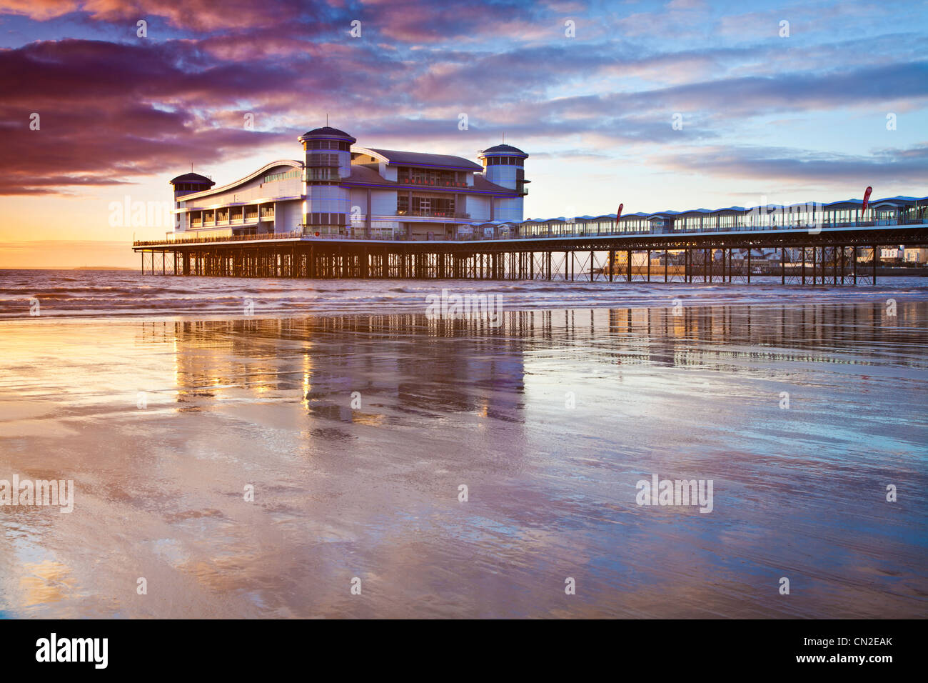 Sunset over the Grand Pier at Weston-Super-Mare, Somerset, England, UK reflected in the wet sand of the beach at high tide. Stock Photo