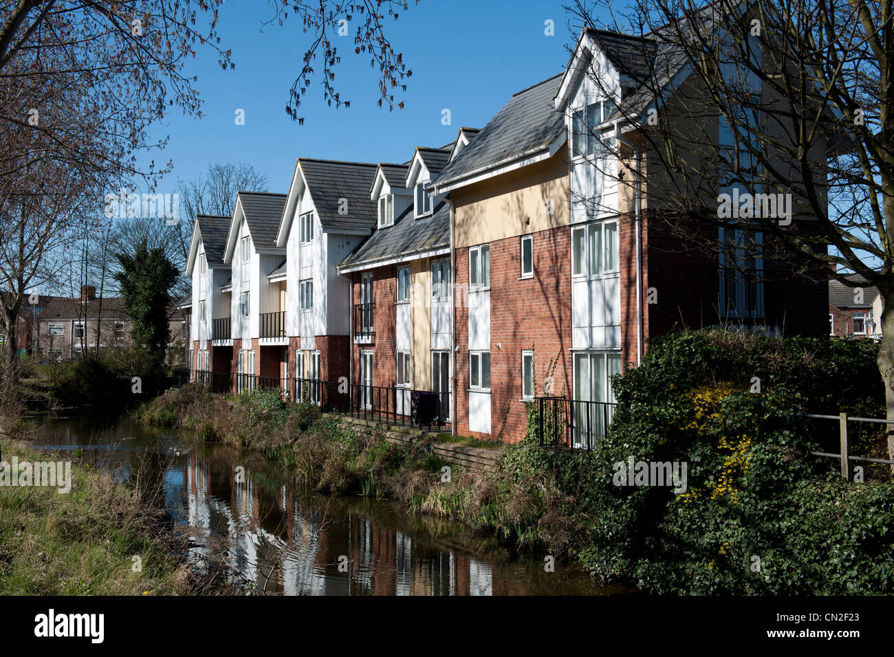 New town housing on the bank of the River Freshney, Grimsby, Lincolnshire, England. Stock Photo