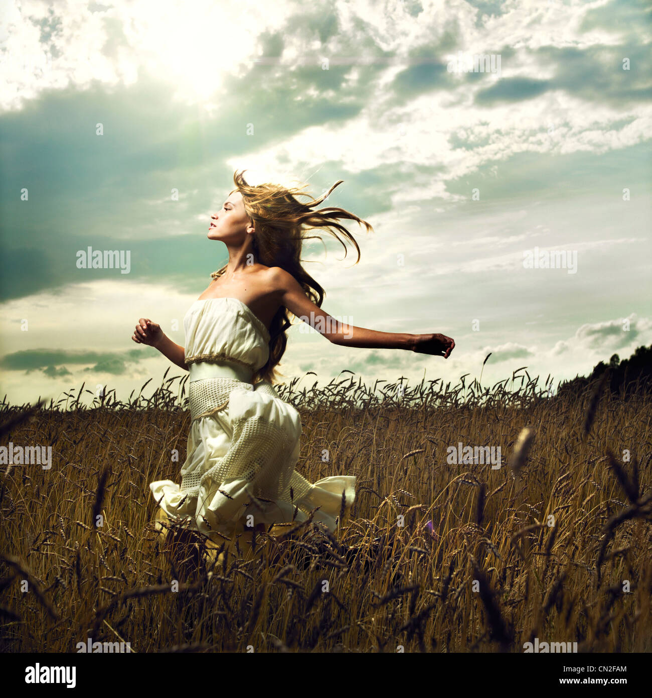 Portrait of romantic woman running across field Stock Photo