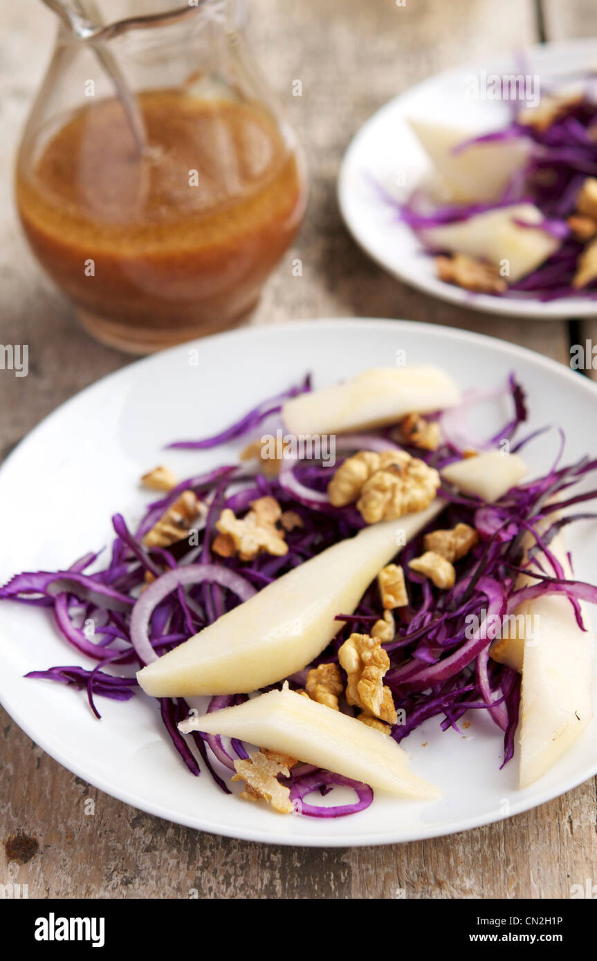 Fresh winter salad with red cabbage, pears, onion and walnuts. Served with an elderberry vinegar and walnut oil dressing. Stock Photo