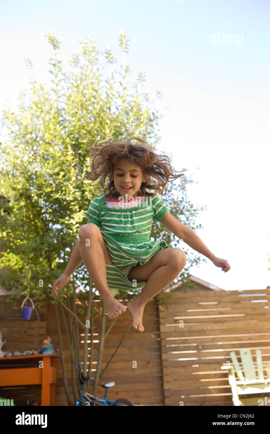 Young girl jumping on trampoline Stock Photo