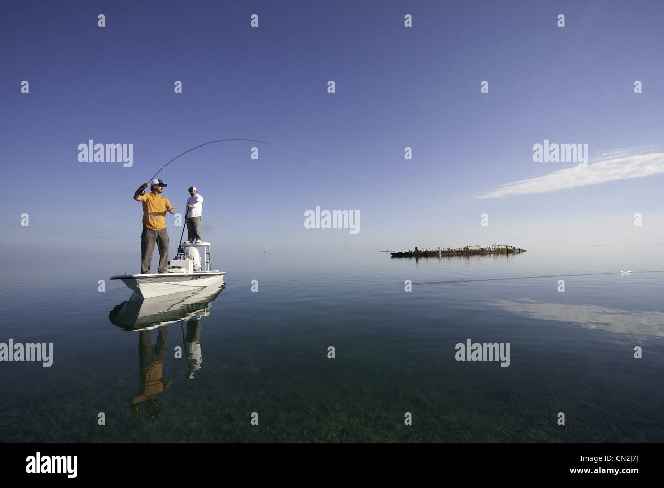 Two Men Fly Fishing in Boat Near Shipwreck, Florida Keys, USA Stock Photo