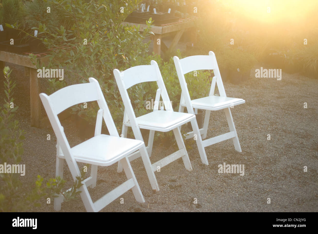 Three folding chairs in garden Stock Photo Alamy