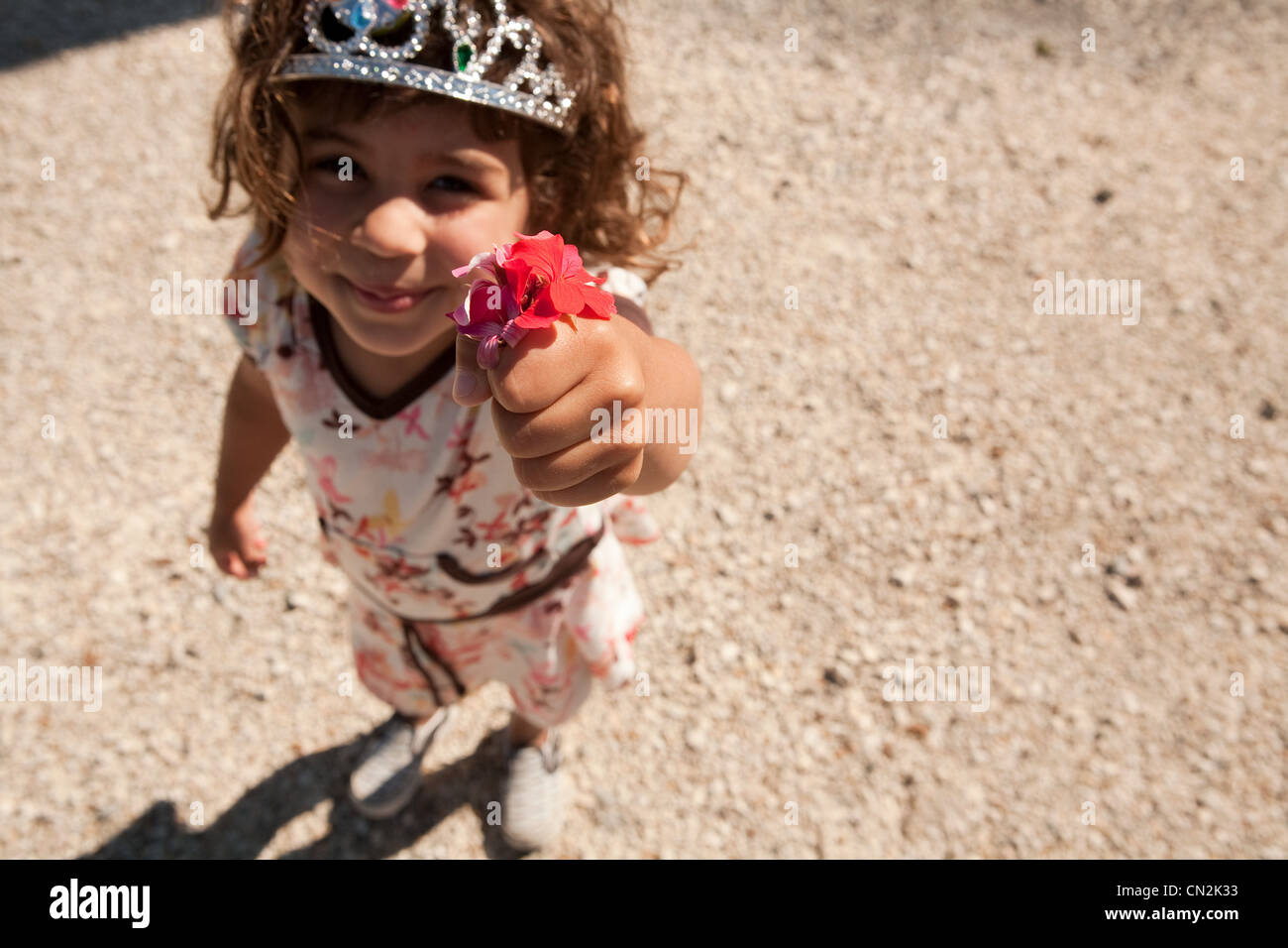 Young girl wearing tiara, holding flower Stock Photo