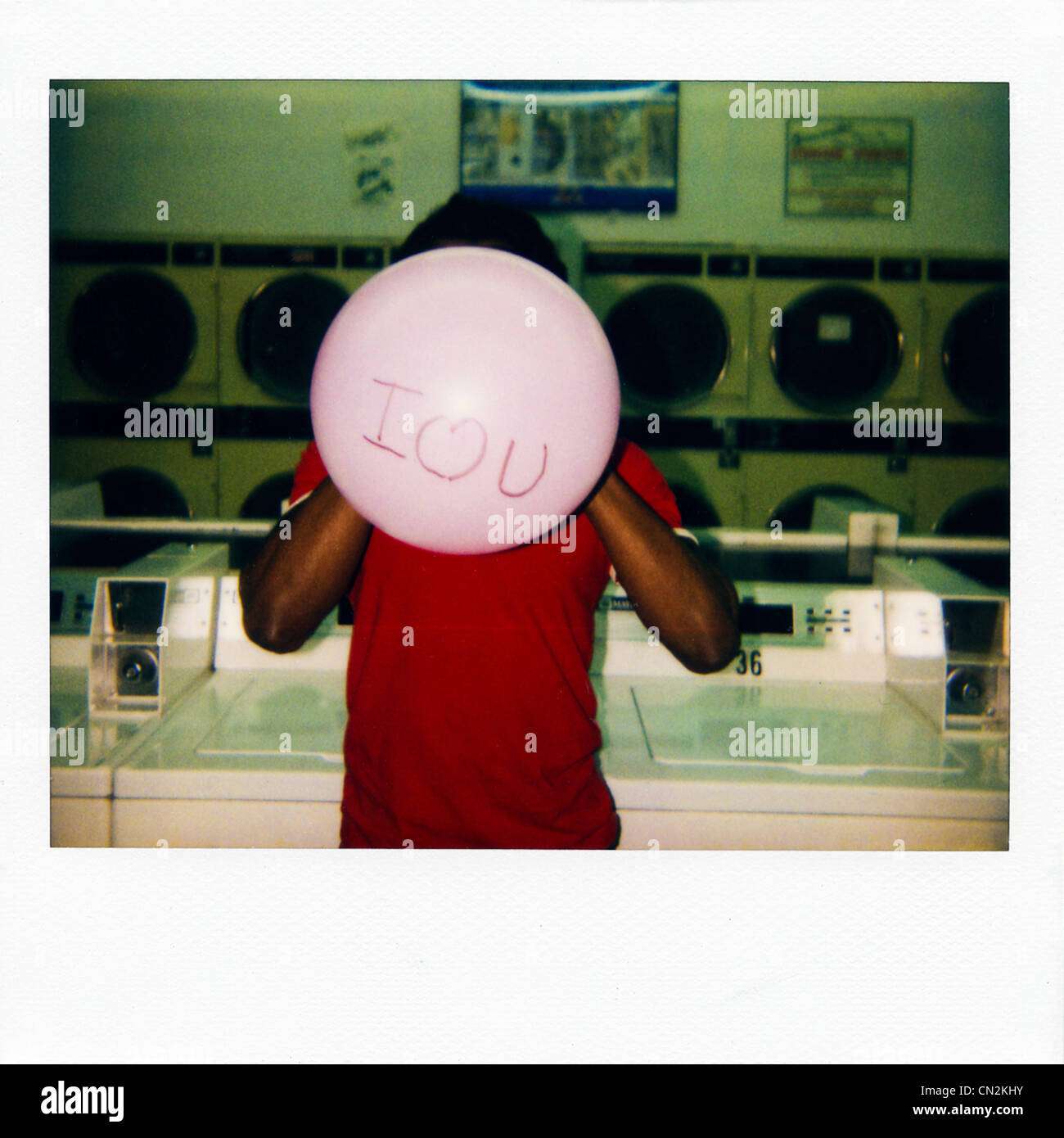 Instant film photograph of man with balloon saying 'I love you' Stock Photo