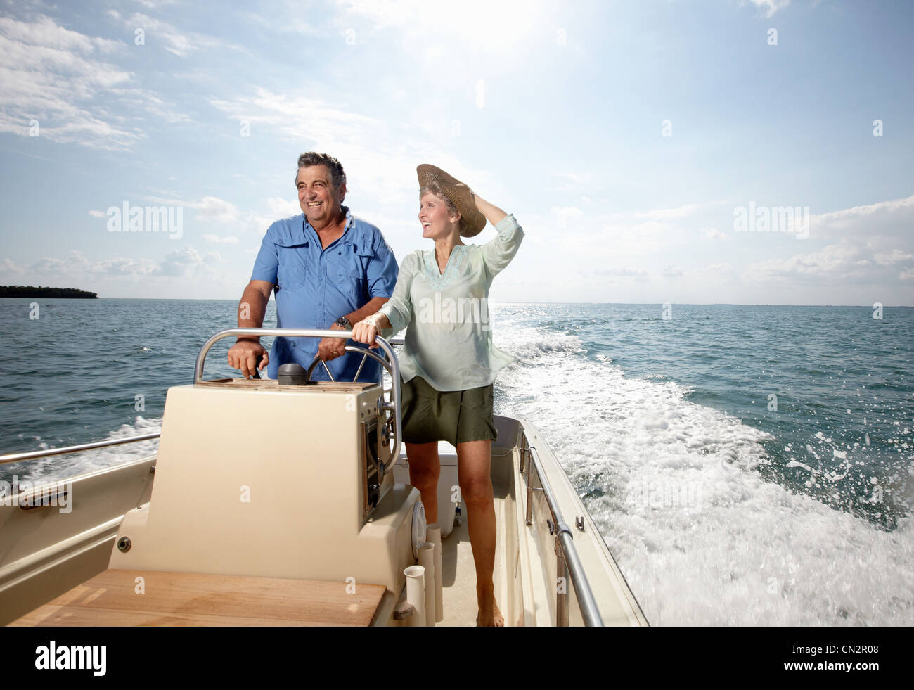 Senior couple driving motorboat Stock Photo - Alamy