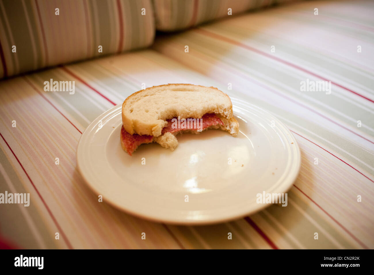 Half eaten sandwich on plate Stock Photo