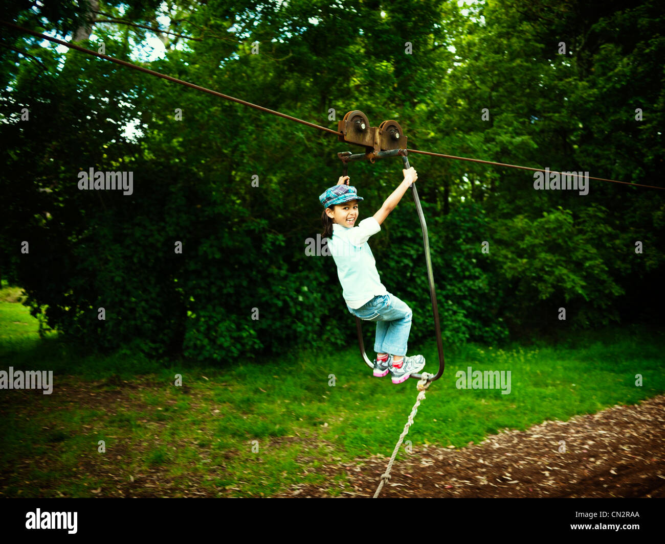 Girl on flying fox in adventure playground, New Zealand. Stock Photo