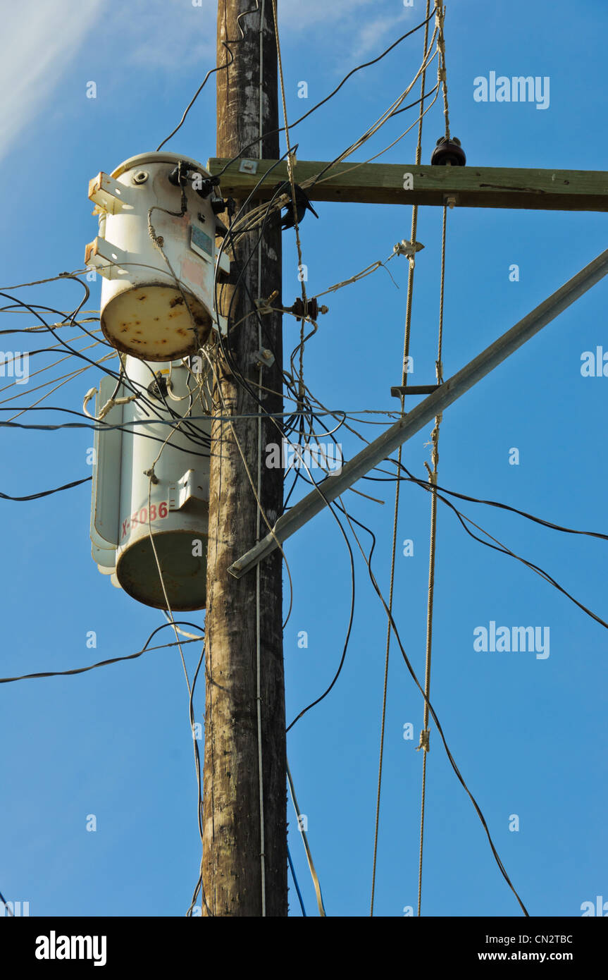 Power lines on wooden post with chaotic dangerous wiring and