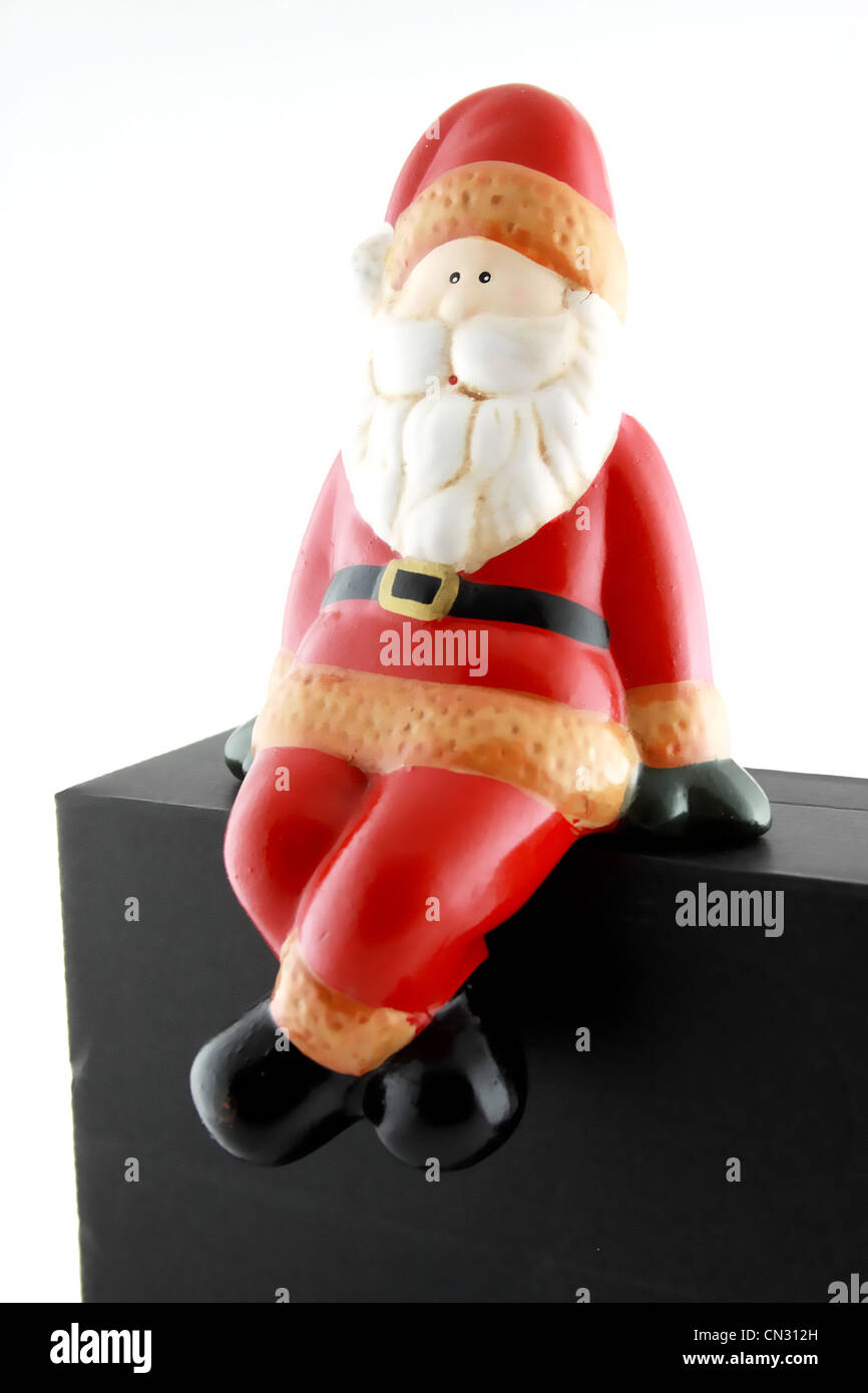 Santa Claus sitting on black box isolated on white background Stock ...