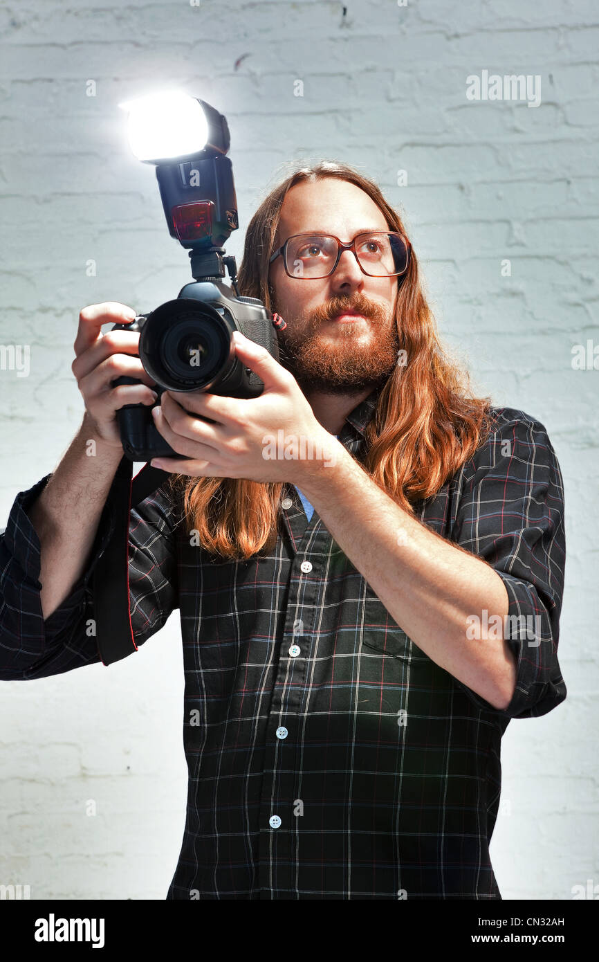 Photographer with flash on camera Stock Photo
