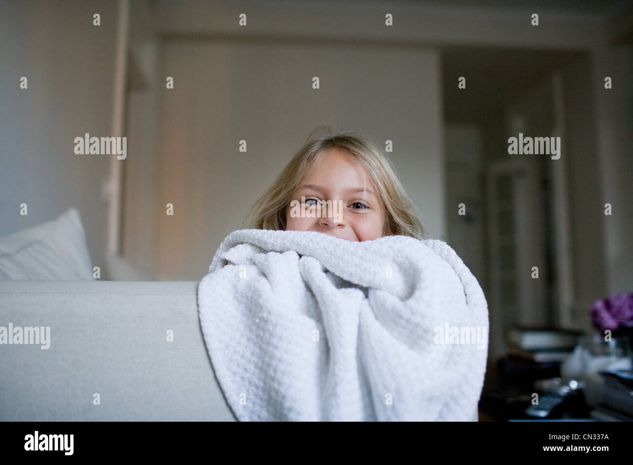 Girl peeking over blanket Stock Photo