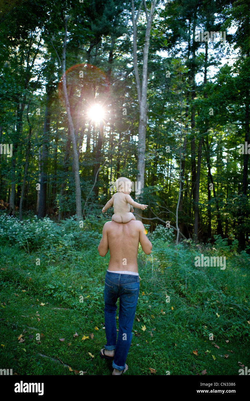 Father carrying baby girl on shoulders in forest Stock Photo