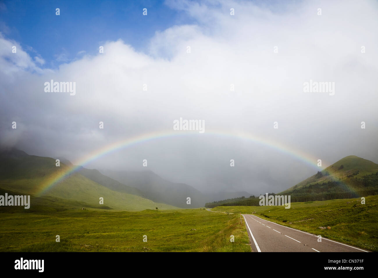 Scotland, Highland Region, Empty Road and Rainbow Stock Photo