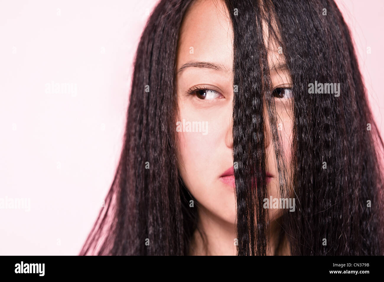 Woman with crimped hair covering face Stock Photo