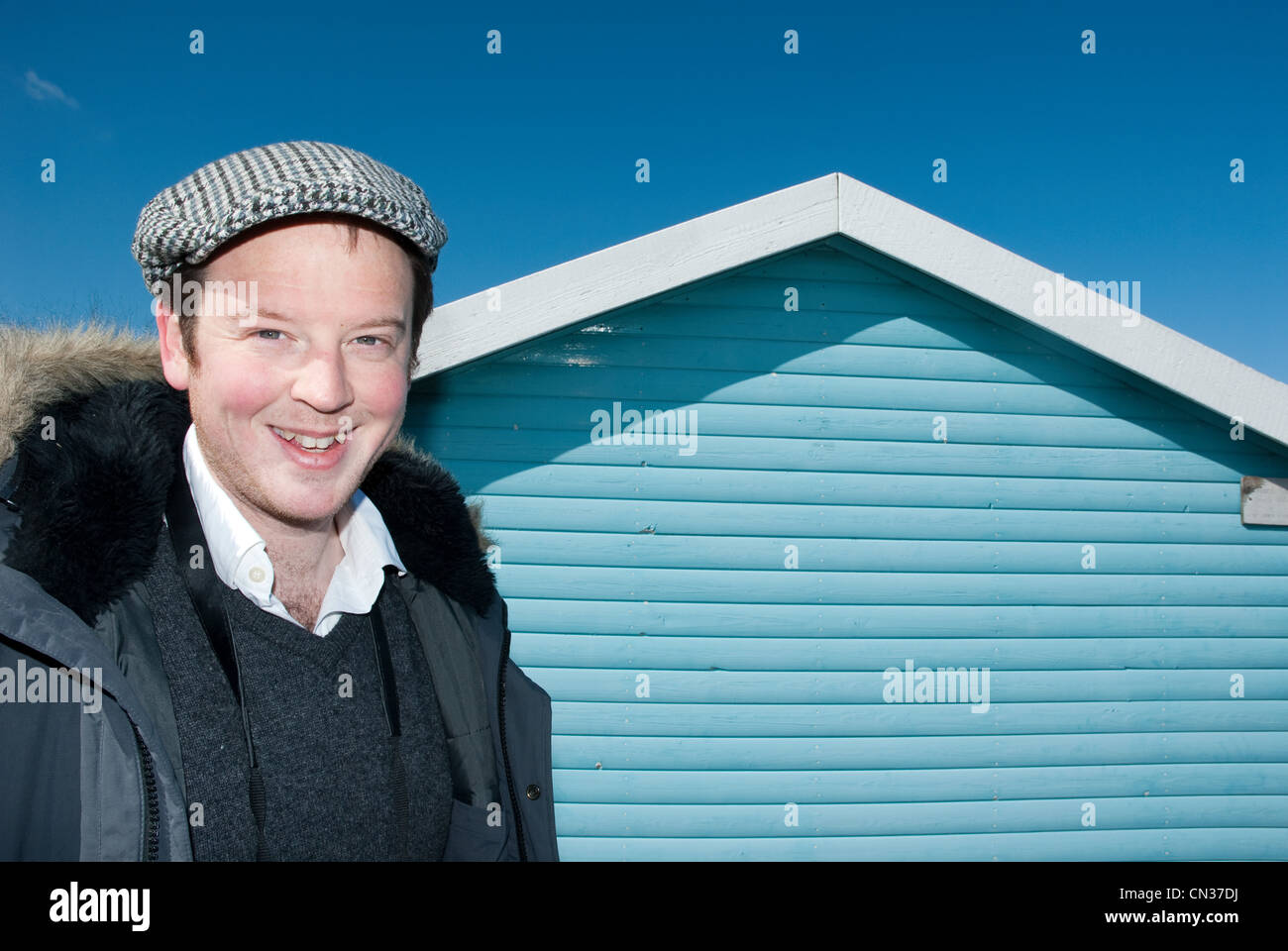 Man outside beach hut, Whitstable, Kent, England, UK Stock Photo