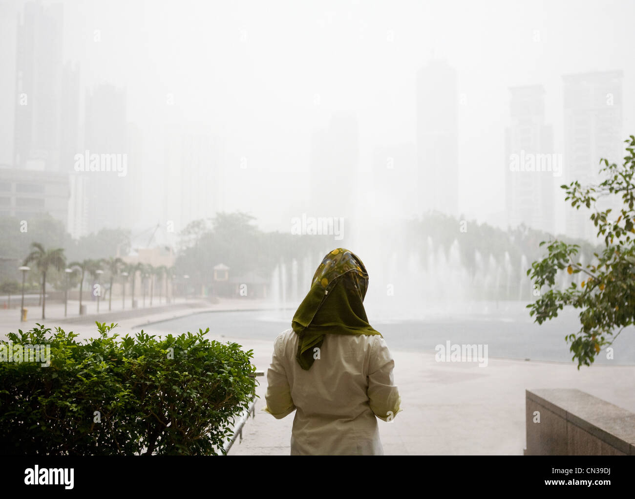 Young muslim woman waiting for rain to end, Kuala Lumpur, Malaysia Stock Photo