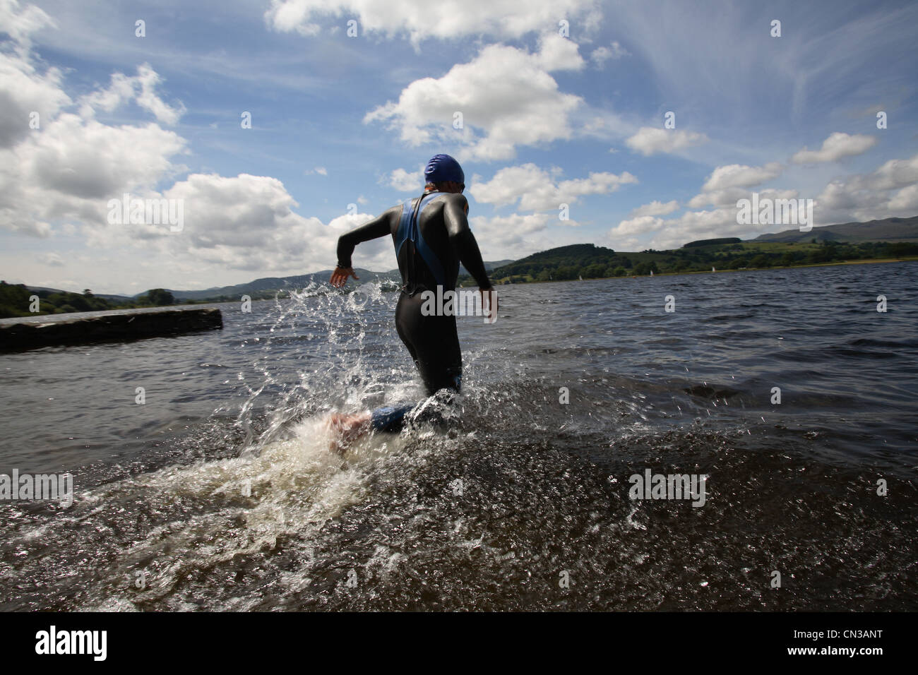 Triathlete swimmer running into water Stock Photo