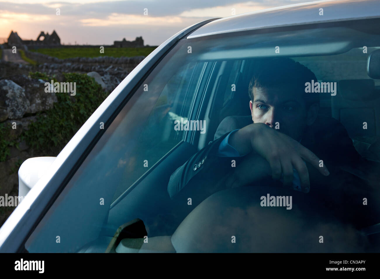 Businessman leaning on steering wheel in car Stock Photo Alamy
