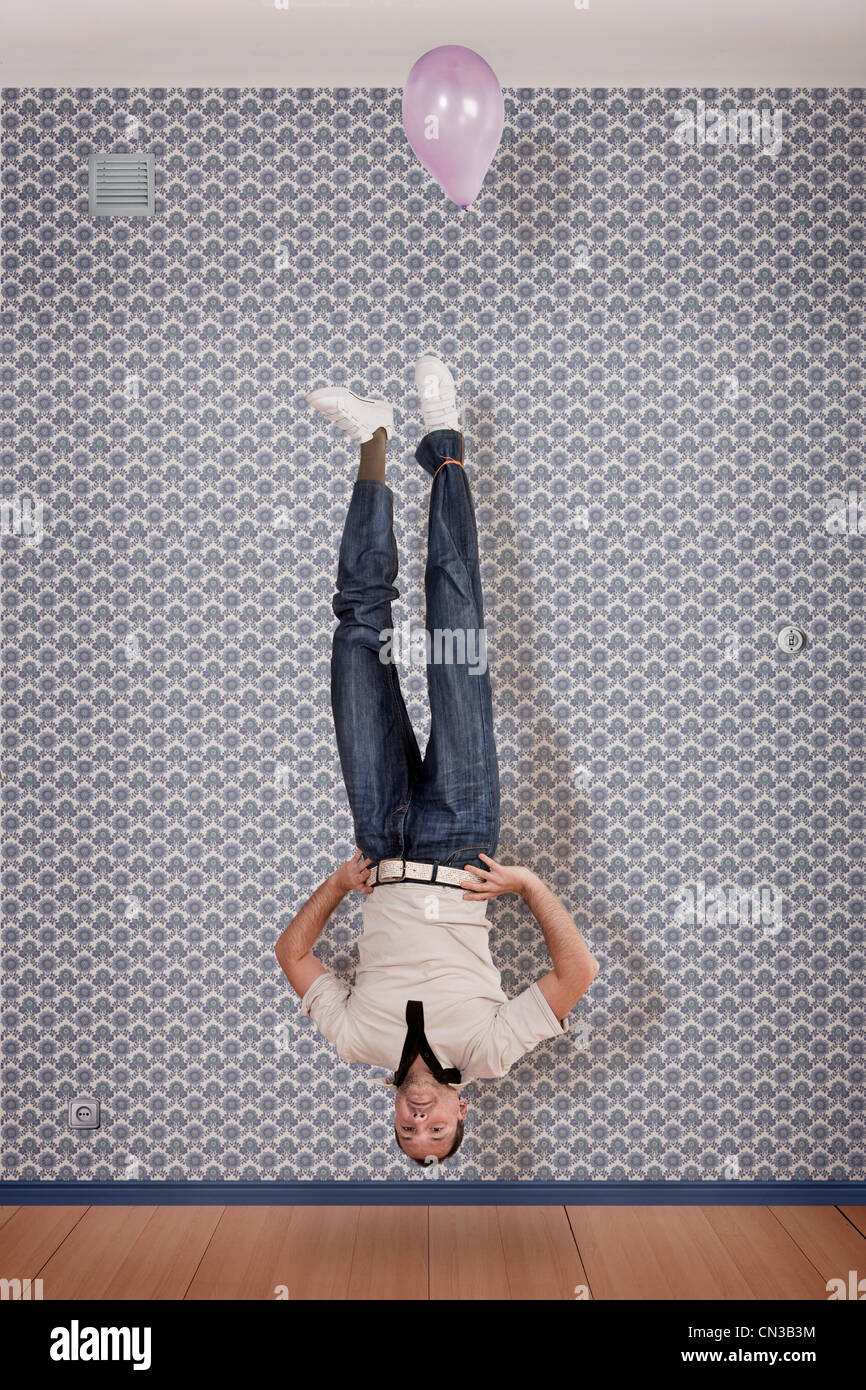 Mature man floating upside down with balloon Stock Photo Alamy