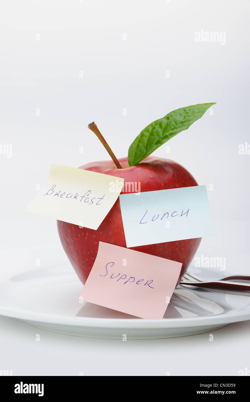Apple with paper notes. Inscriptions on the notes Breakfast, lunch and ...
