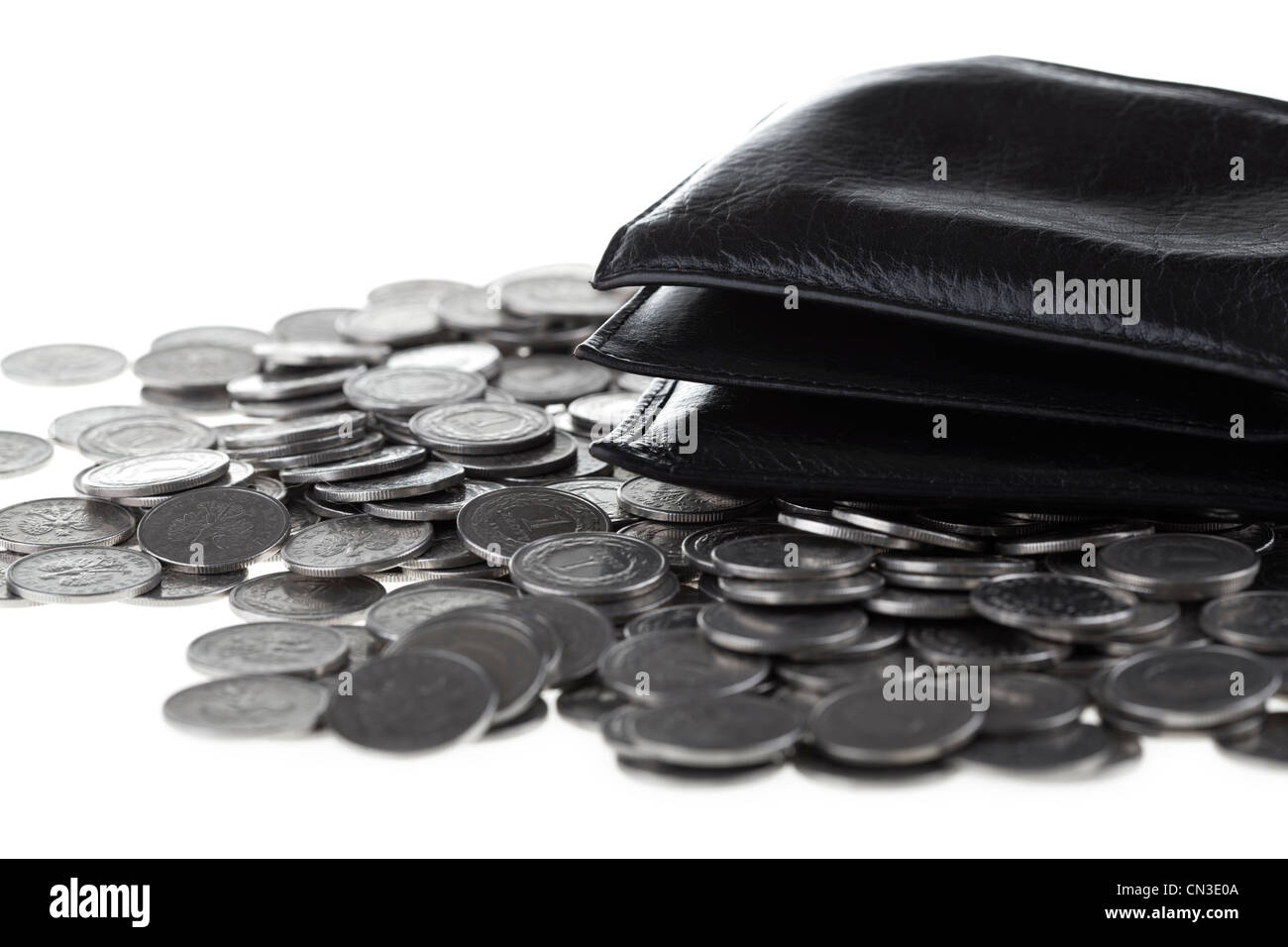 Black wallet laying on one polish zloty coins background. Money and savings concept. Stock Photo