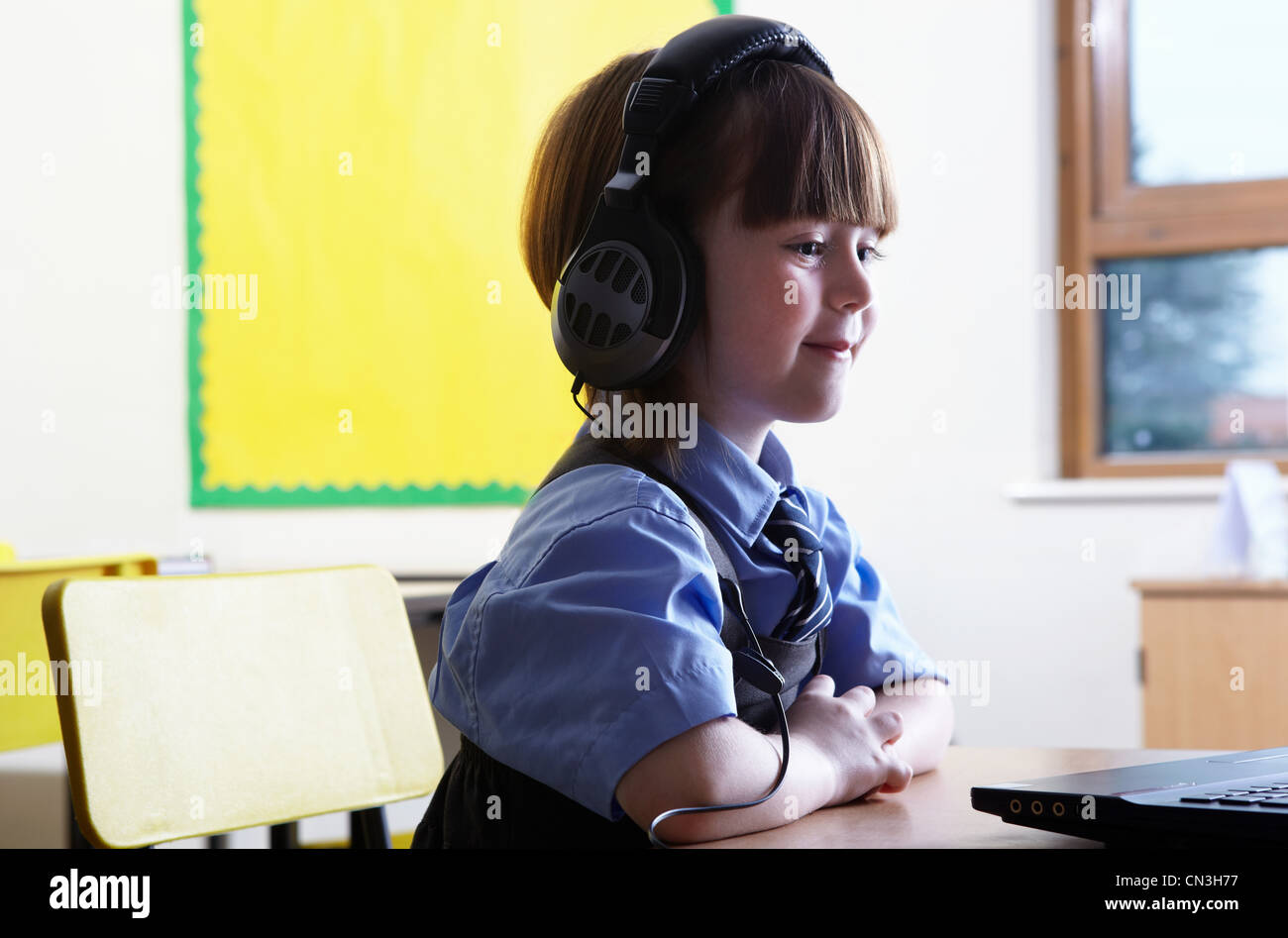 School girl wearing headphones and looking at computer in classroom Stock Photo Alamy