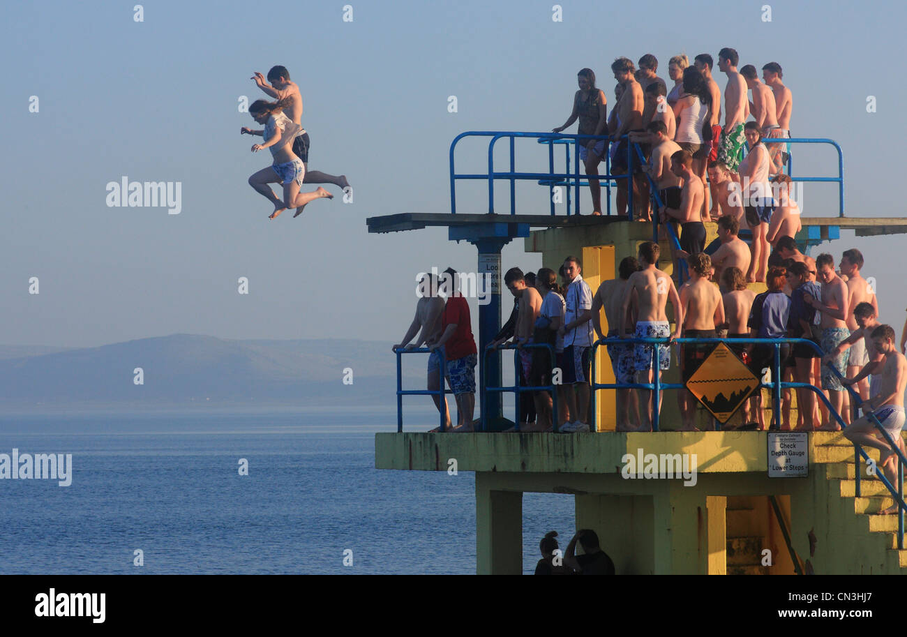 Blackrock diving board in Galway in the summertime, crowds of people