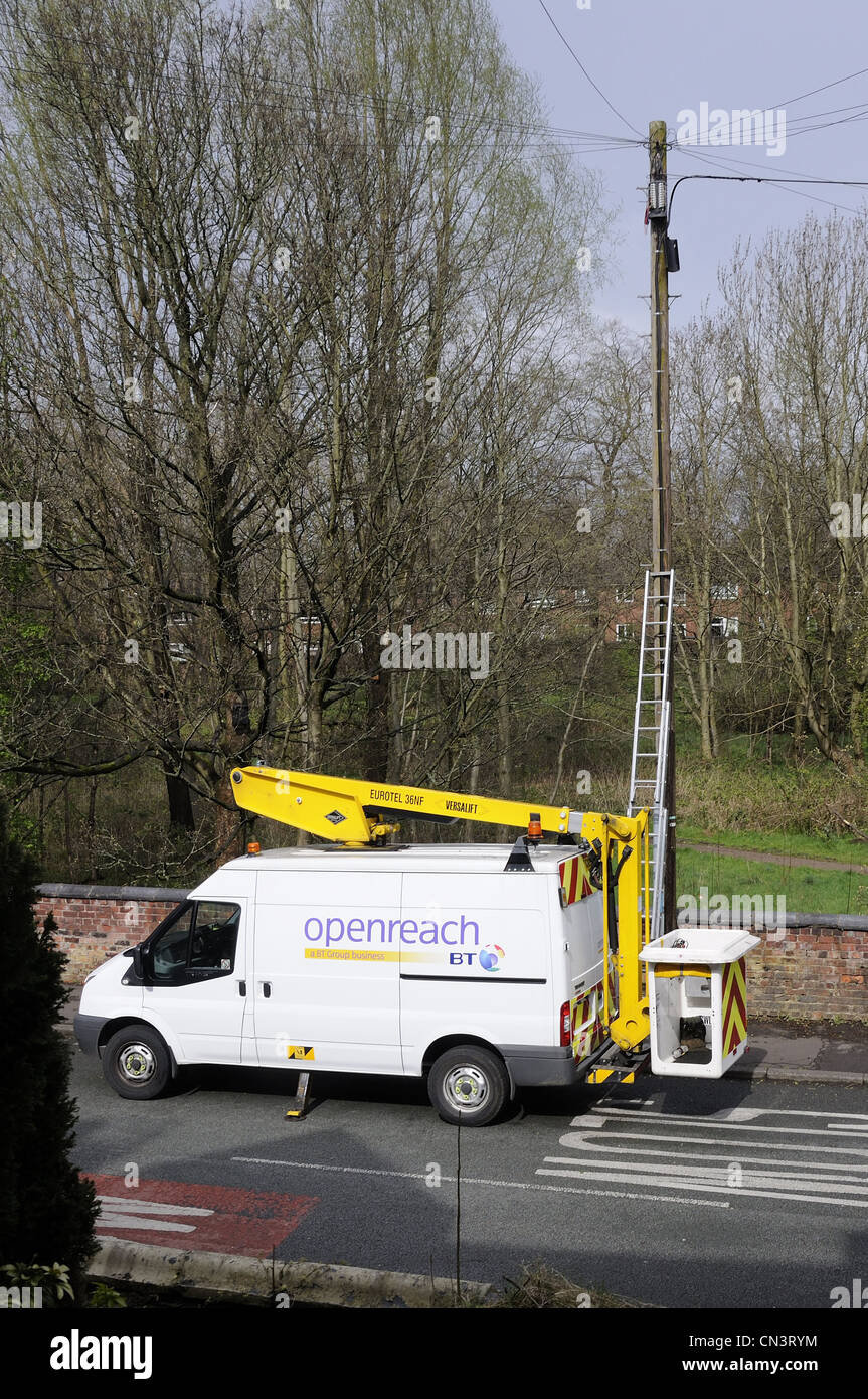 Openreach van with hydraulic arm parked by telephone pole with cover off the junction box Stock Photo