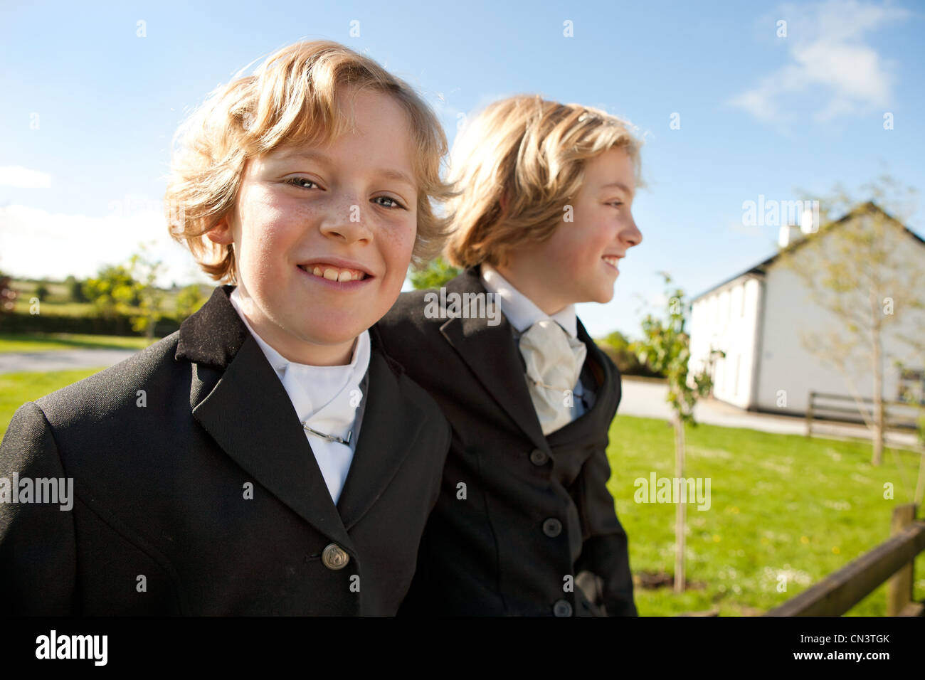 Boys wearing horse riding clothes, smiling Stock Photo