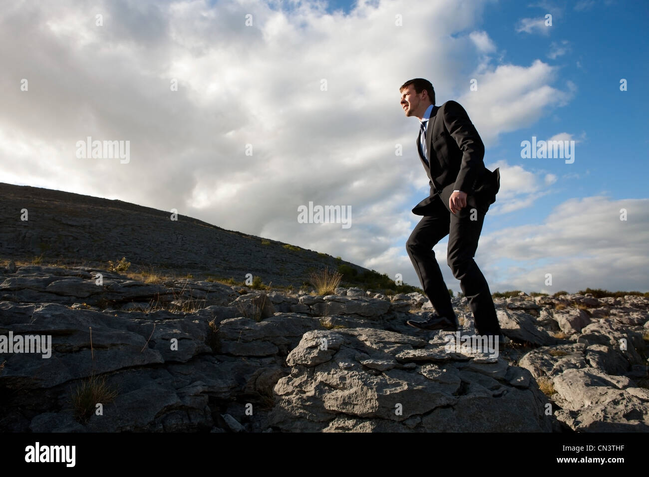 Businessman walking in remote, rock landscape Stock Photo
