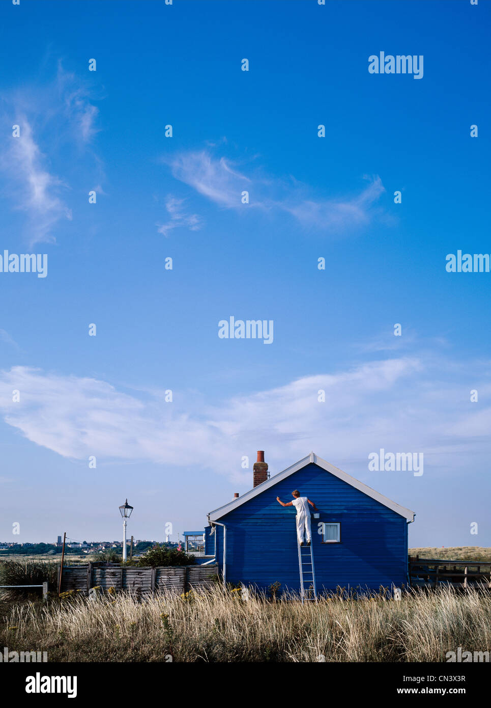 A man painting a house blue Stock Photo