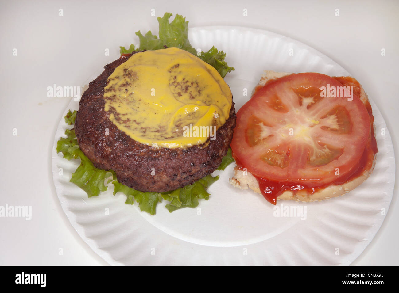 Hamburger with mustard and tomato Stock Photo
