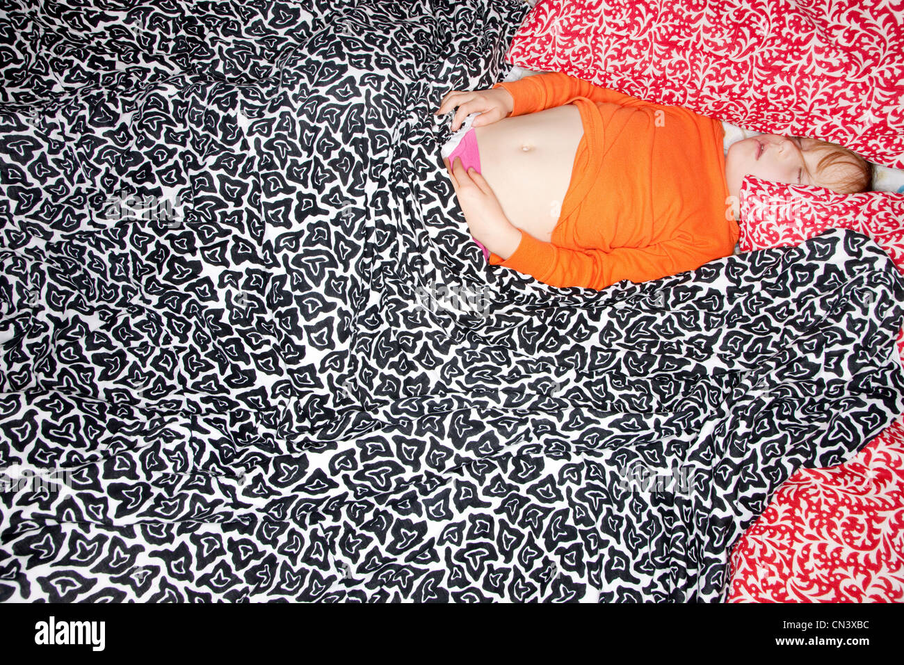 Girl sleeping in patterned sheets Stock Photo